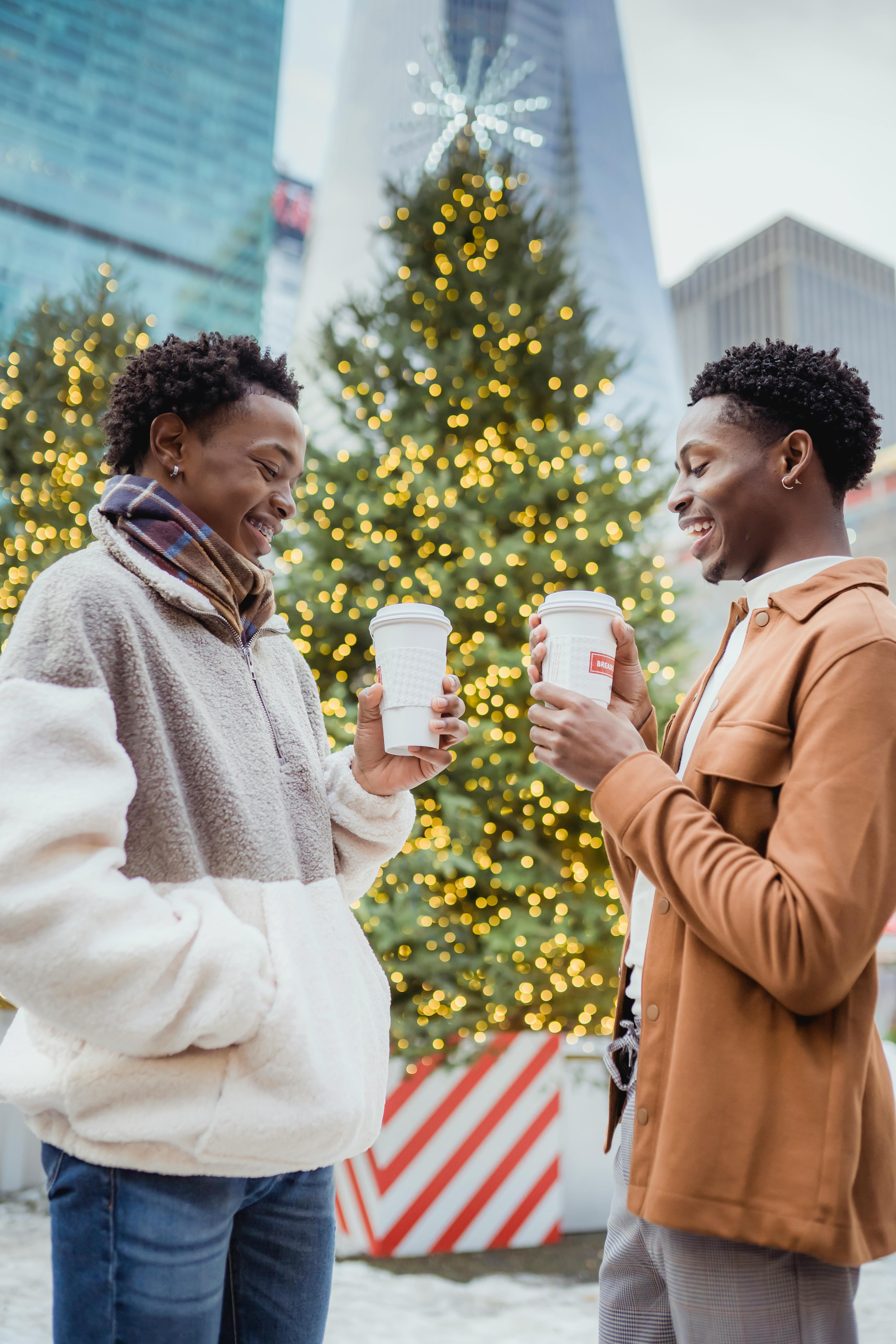 delighted african american gay couple enjoying christmas holidays on street