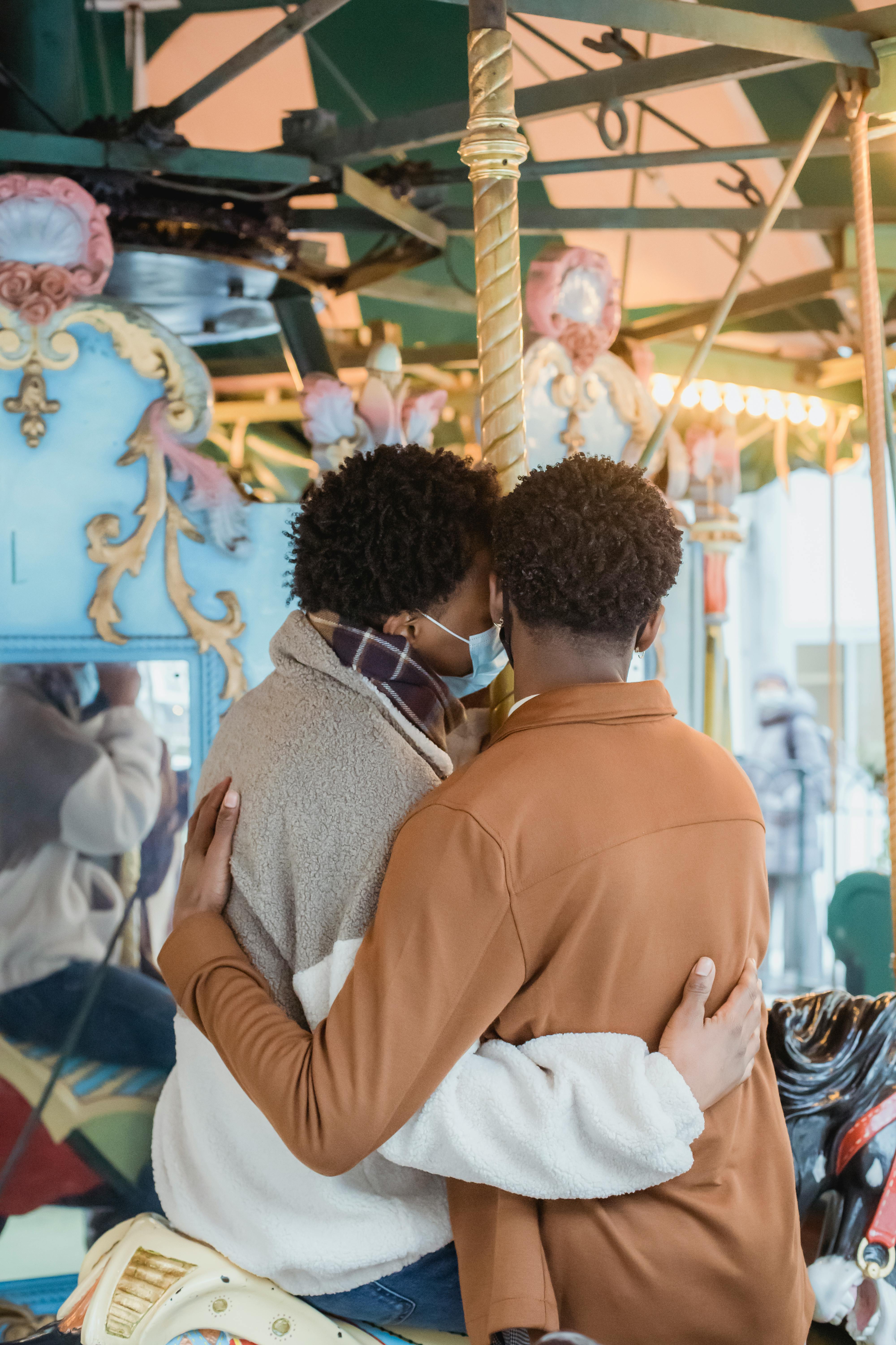 anonymous ethnic homosexual guys embracing on merry go round