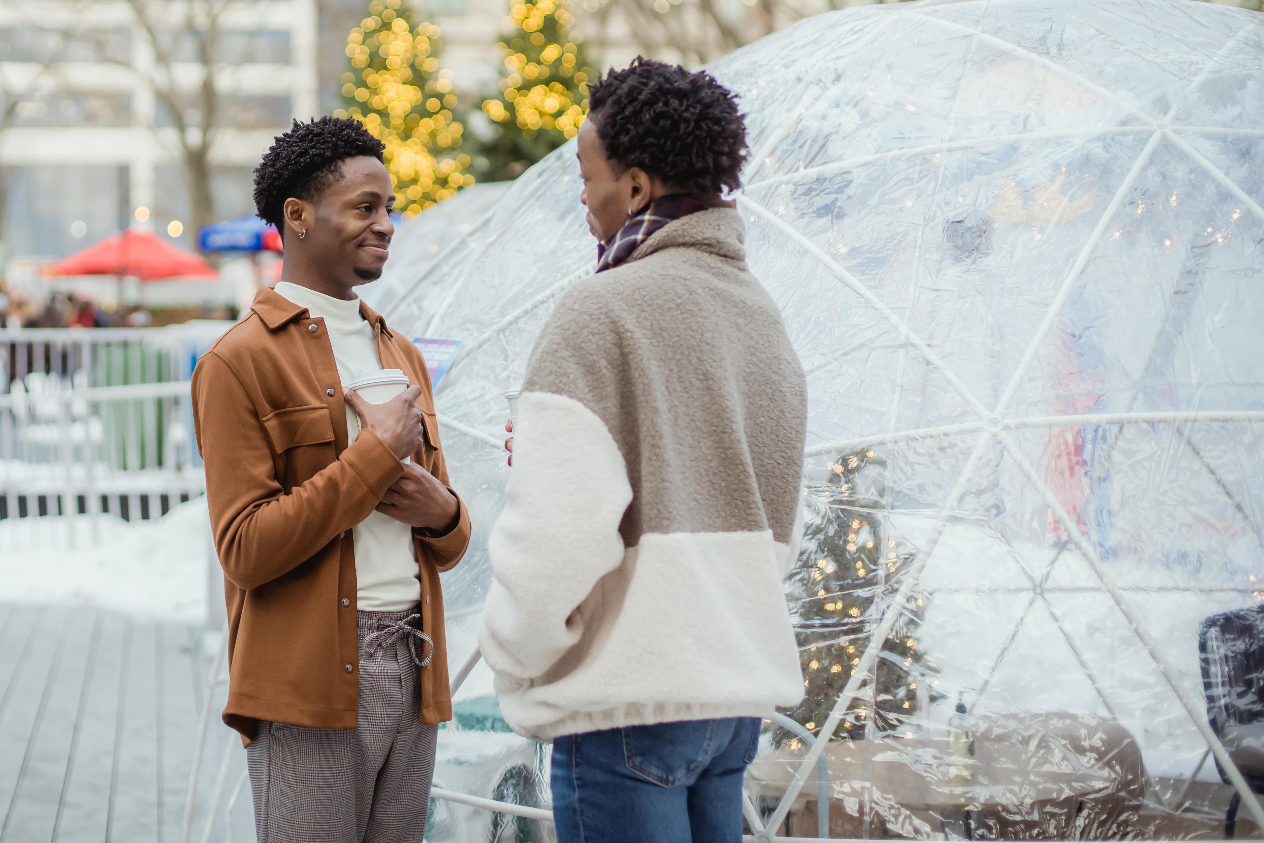 black couple standing outside and talking during holidays