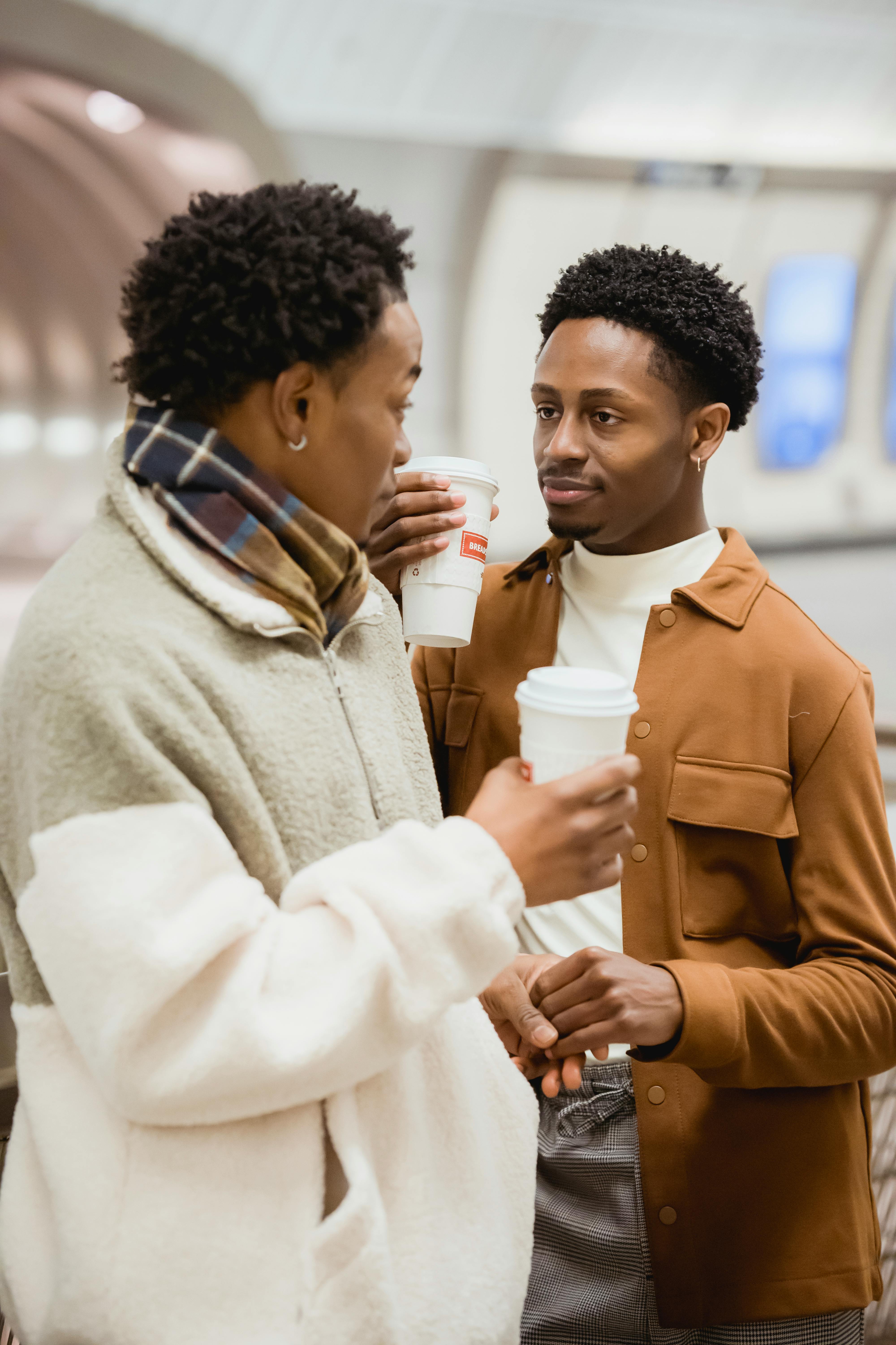 black boyfriends with takeaway coffee talking