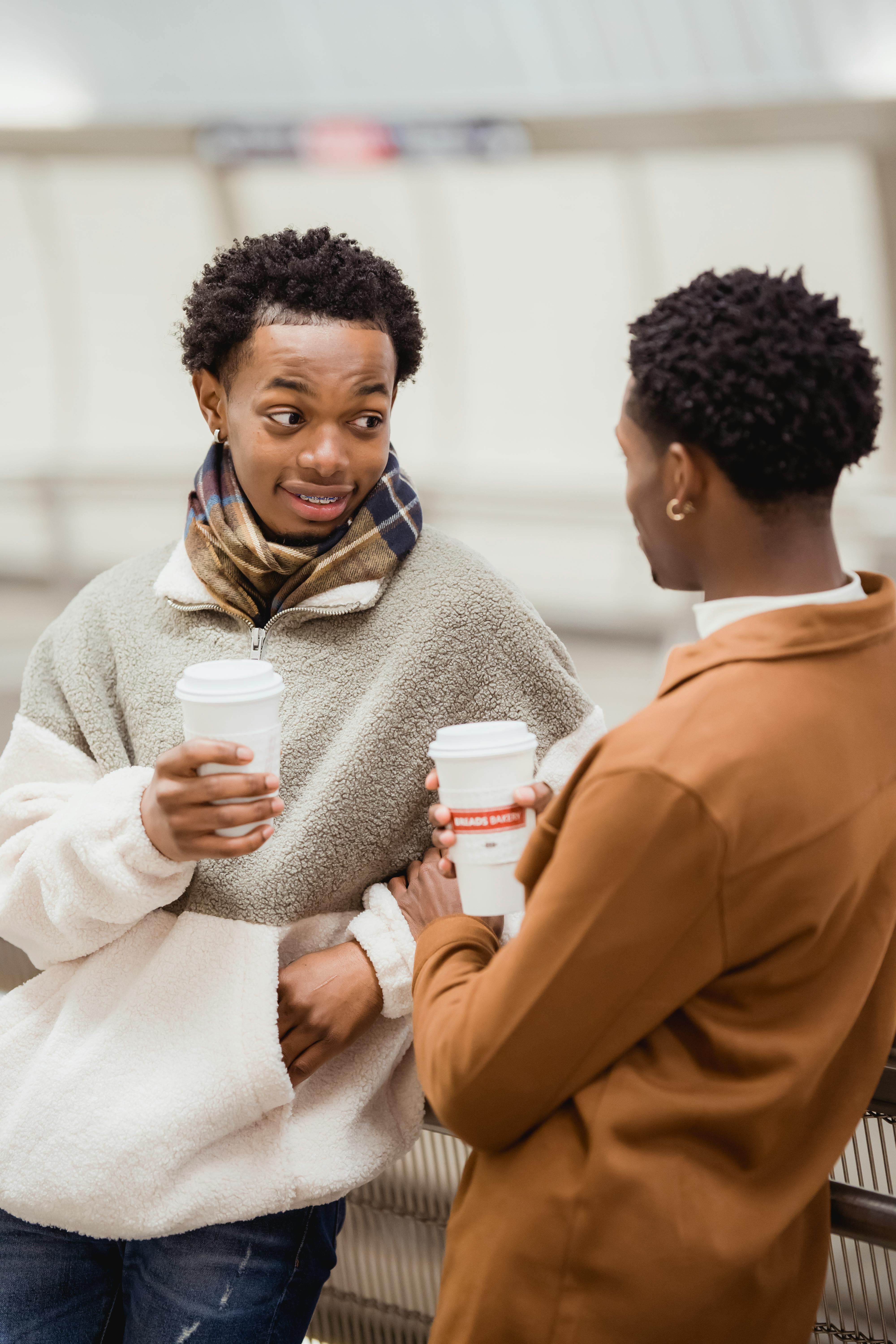 black couple with cups of coffee having interesting communication