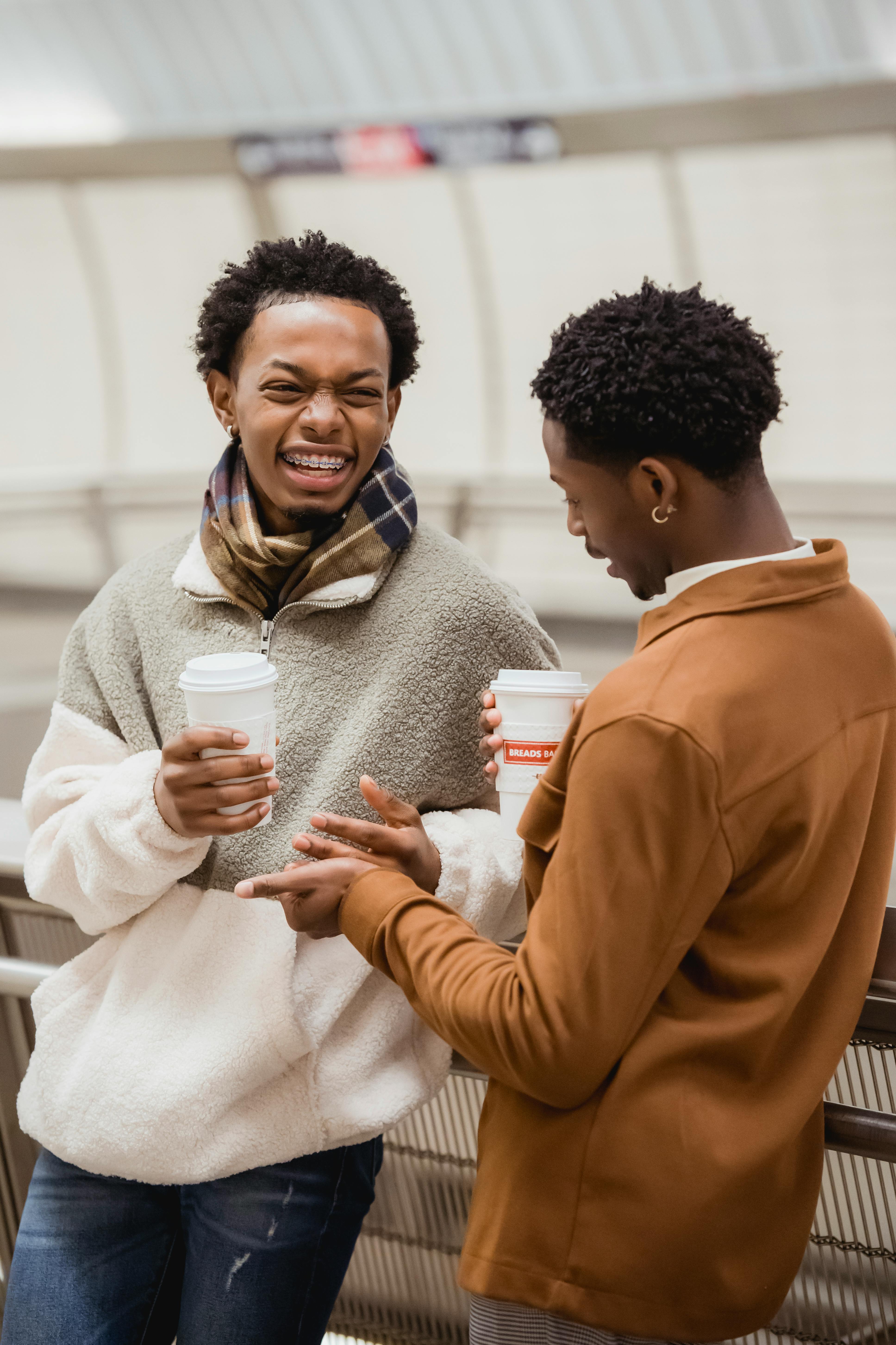 ethnic homosexual couple laughing in metro