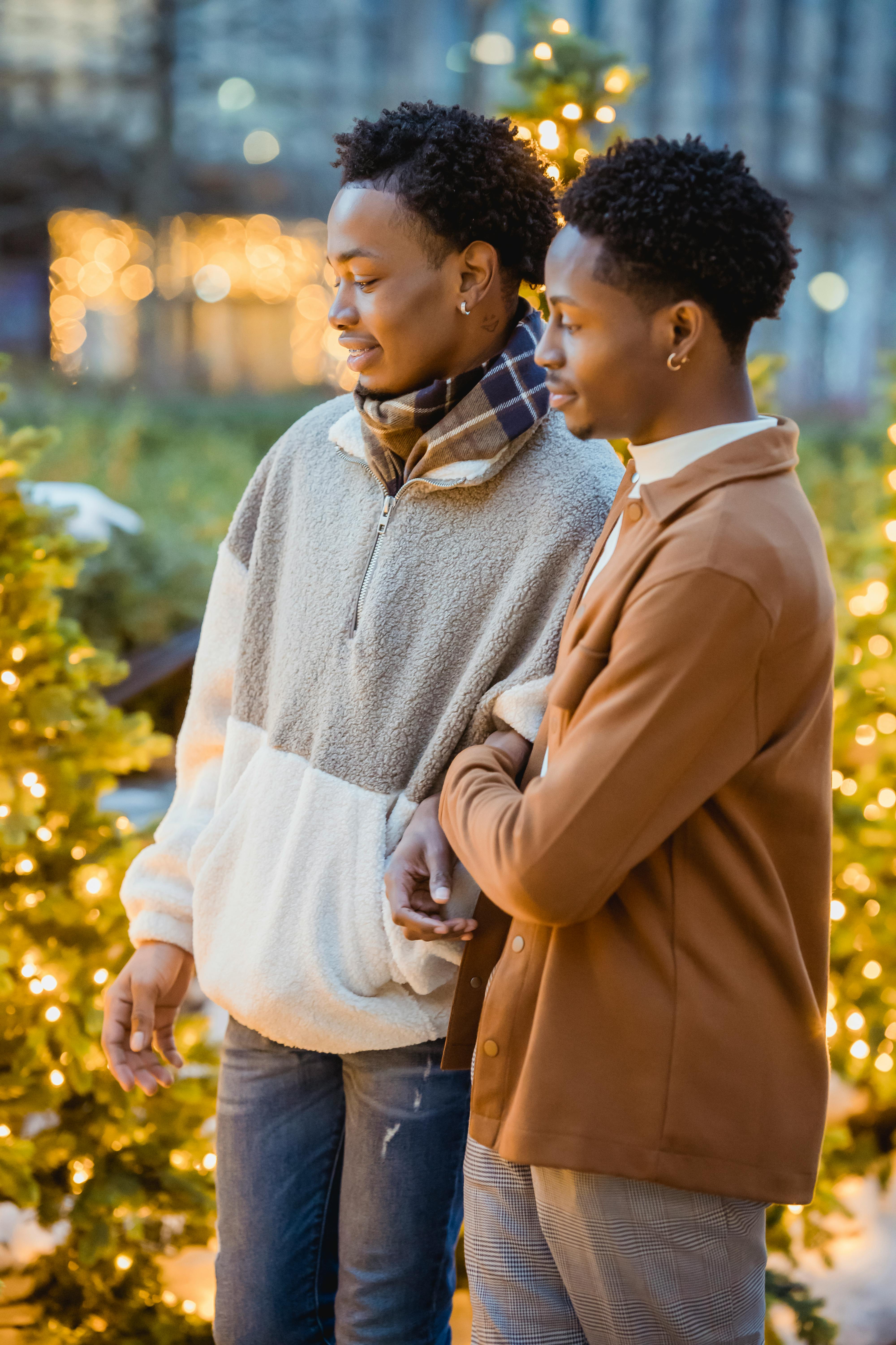 african american homosexual couple in street near decorated christmas trees