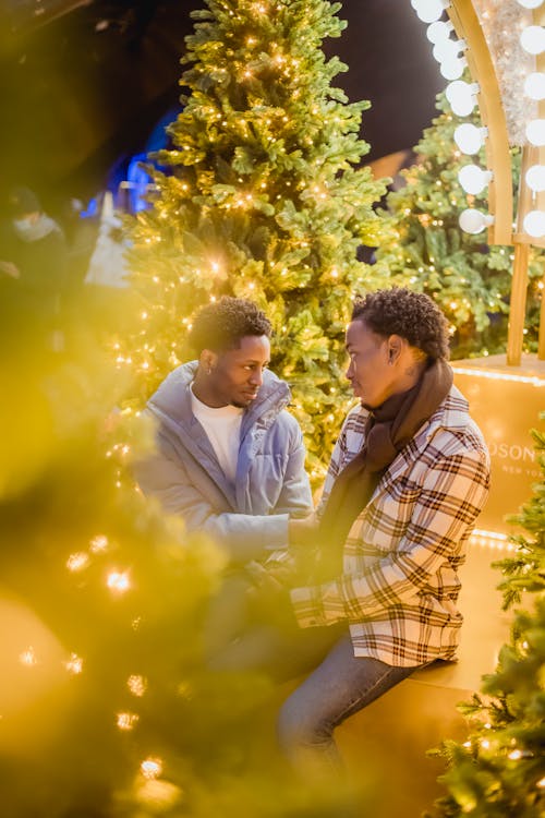 Romantic black gays among glowing Christmas trees
