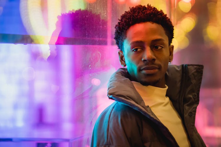 Black Man Leaning On Window Glowing With Neon Light