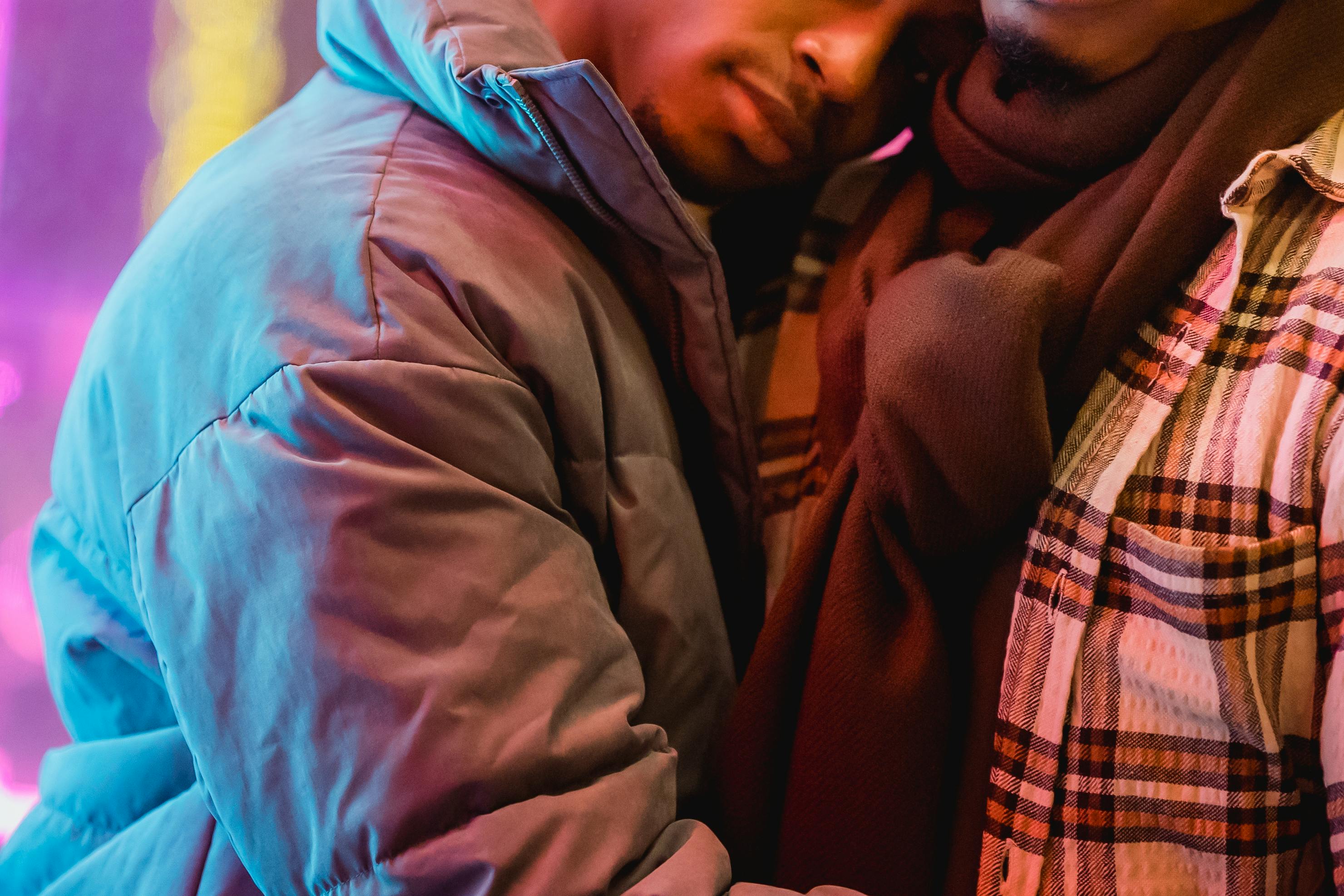 black happy men in warm clothes cuddling