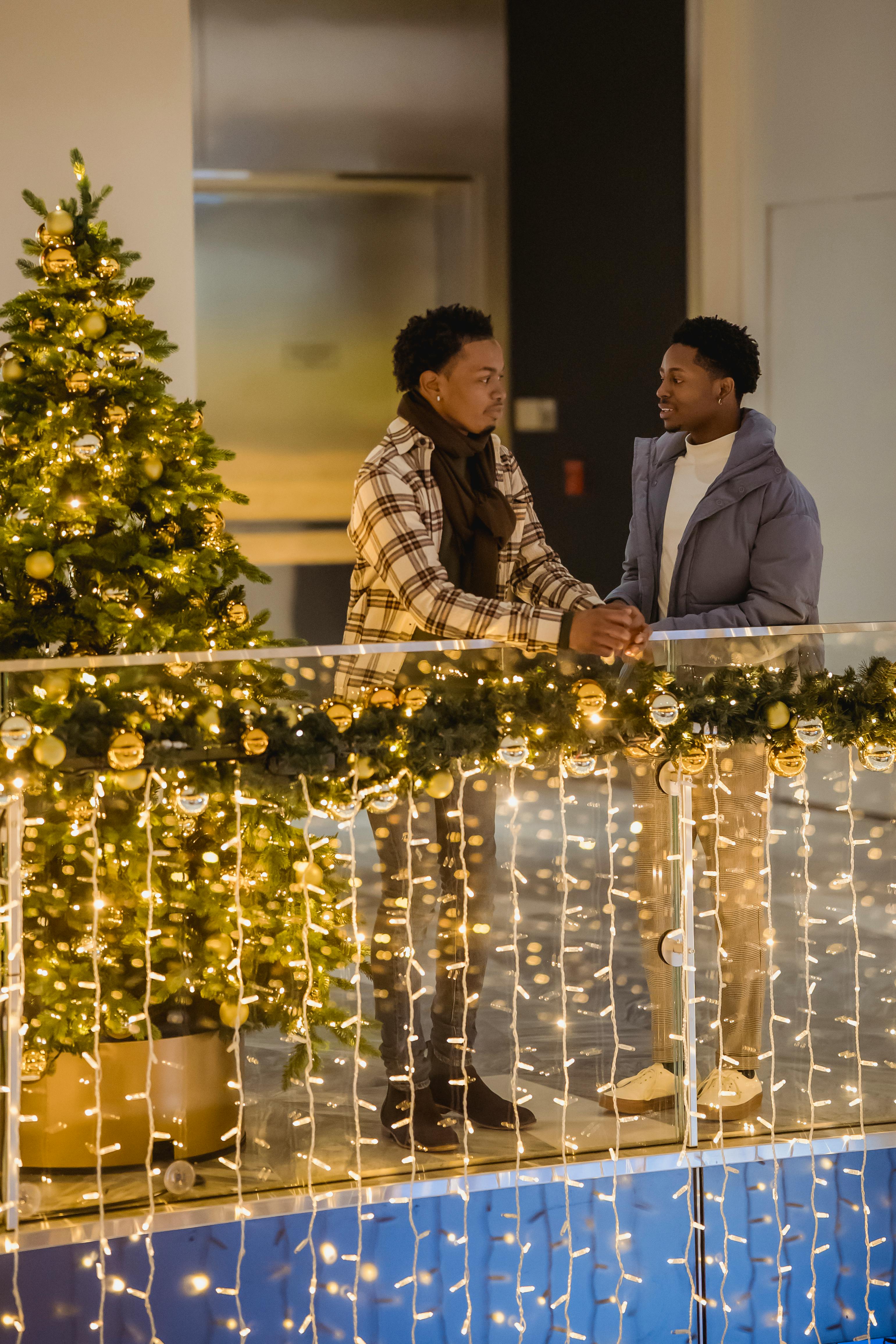 black friends talking among luminous garland and christmas tree