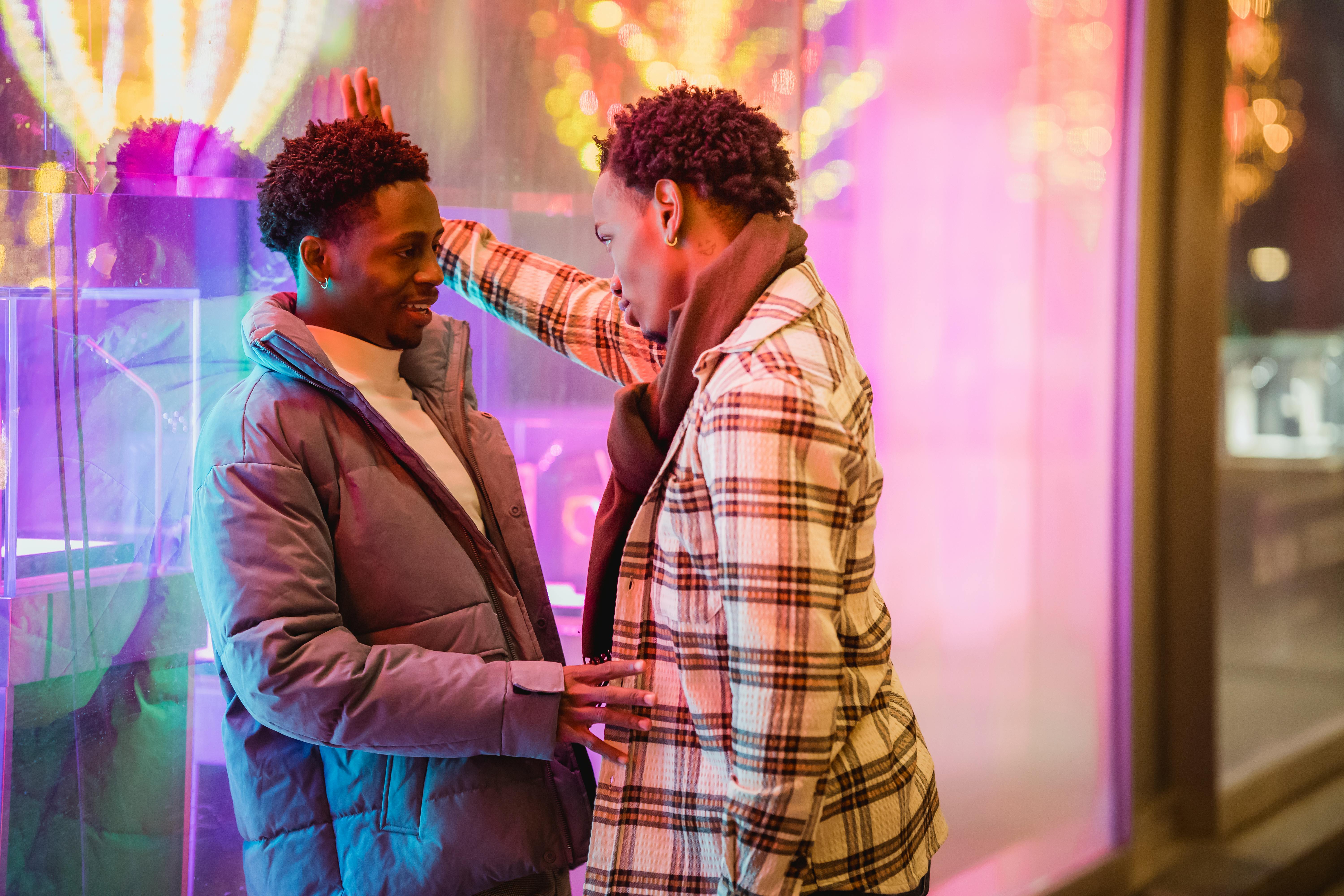 black couple of homosexual men flirting near luminous window