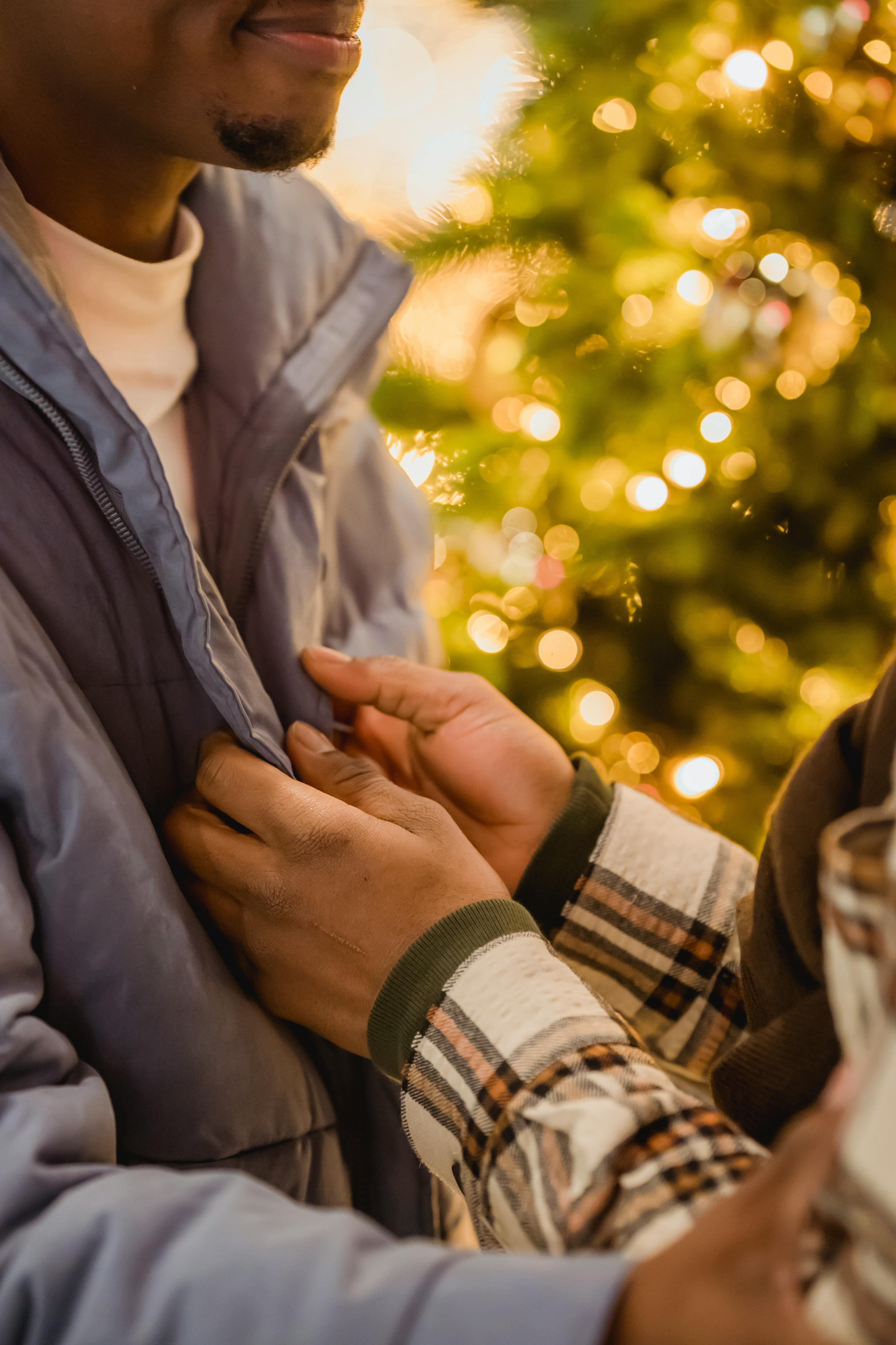 glad black homosexual couple touching each other near christmas tree