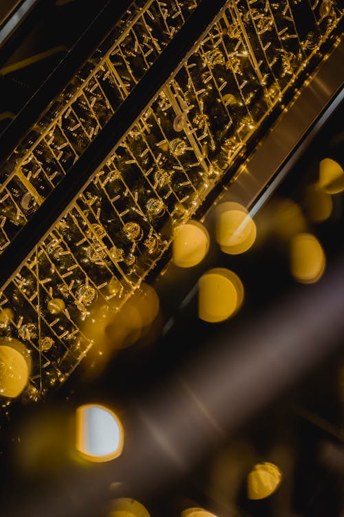 Glowing bright festive garland hanging on construction of escalator in dark shopping center