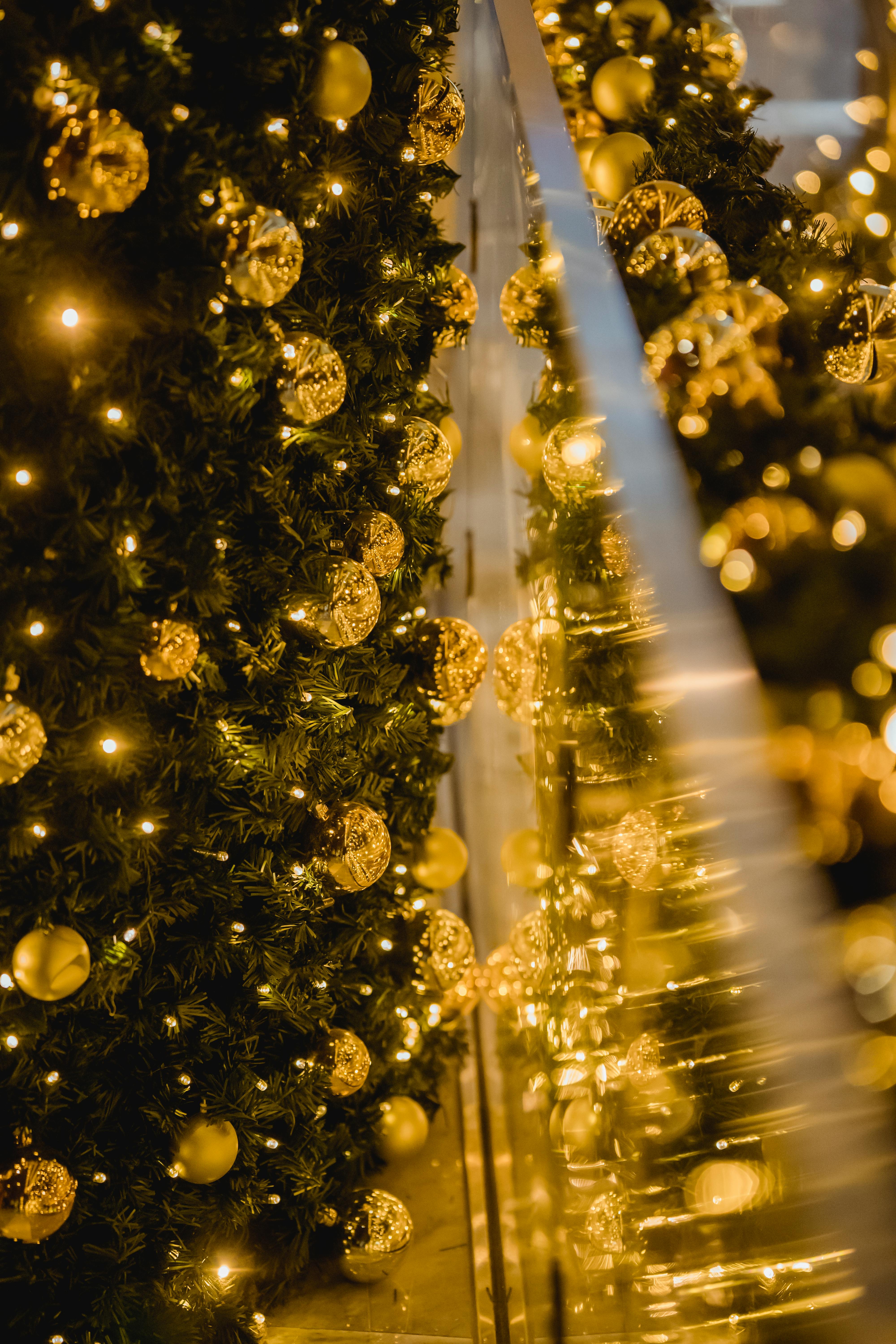 shiny golden baubles and garland hanging on christmas tree