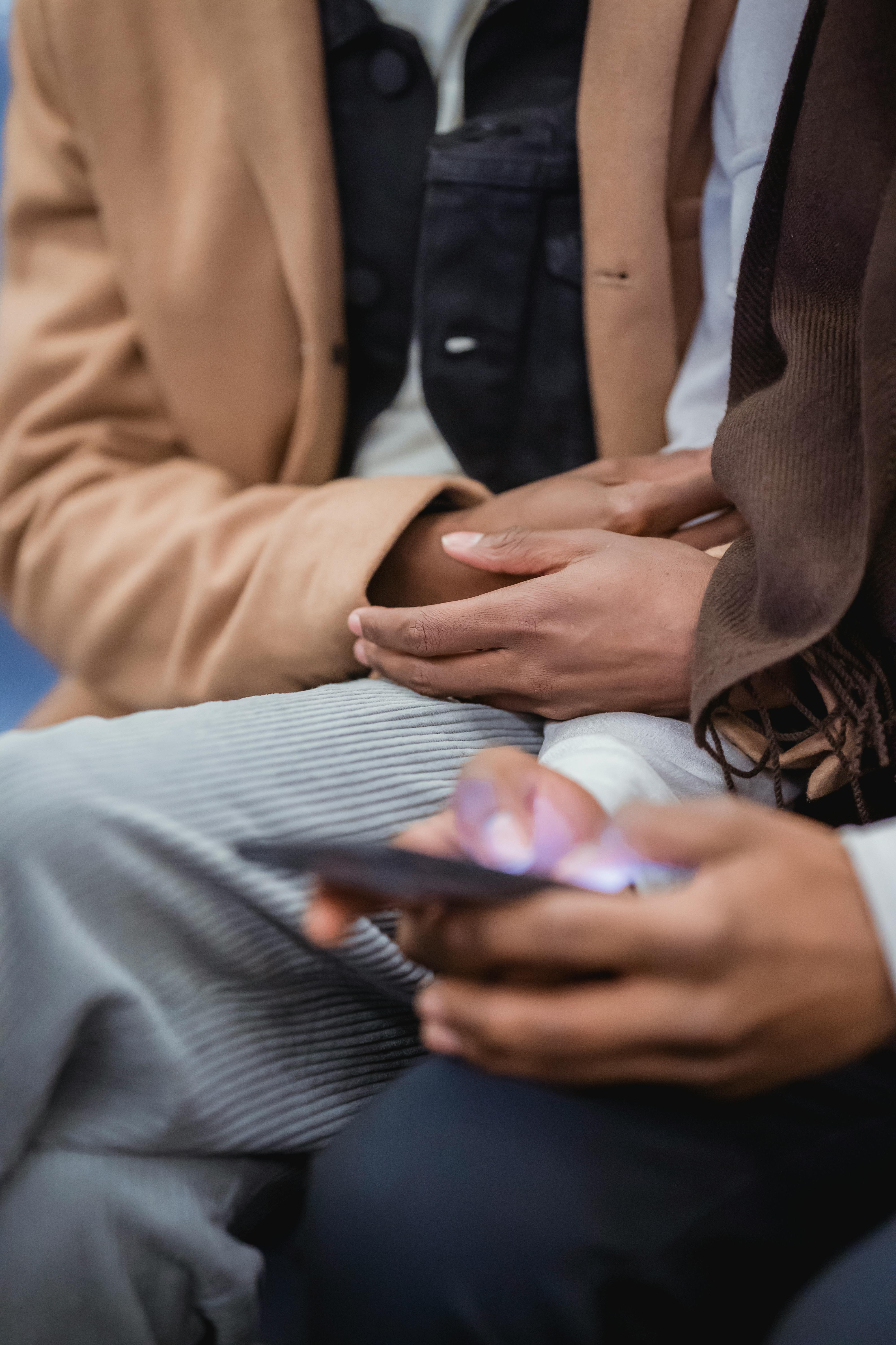 black man browsing smartphone while sitting near boyfriend