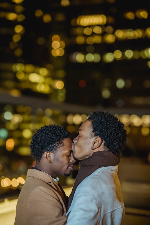 Free Black man kissing forehead of homosexual beloved Stock Photo