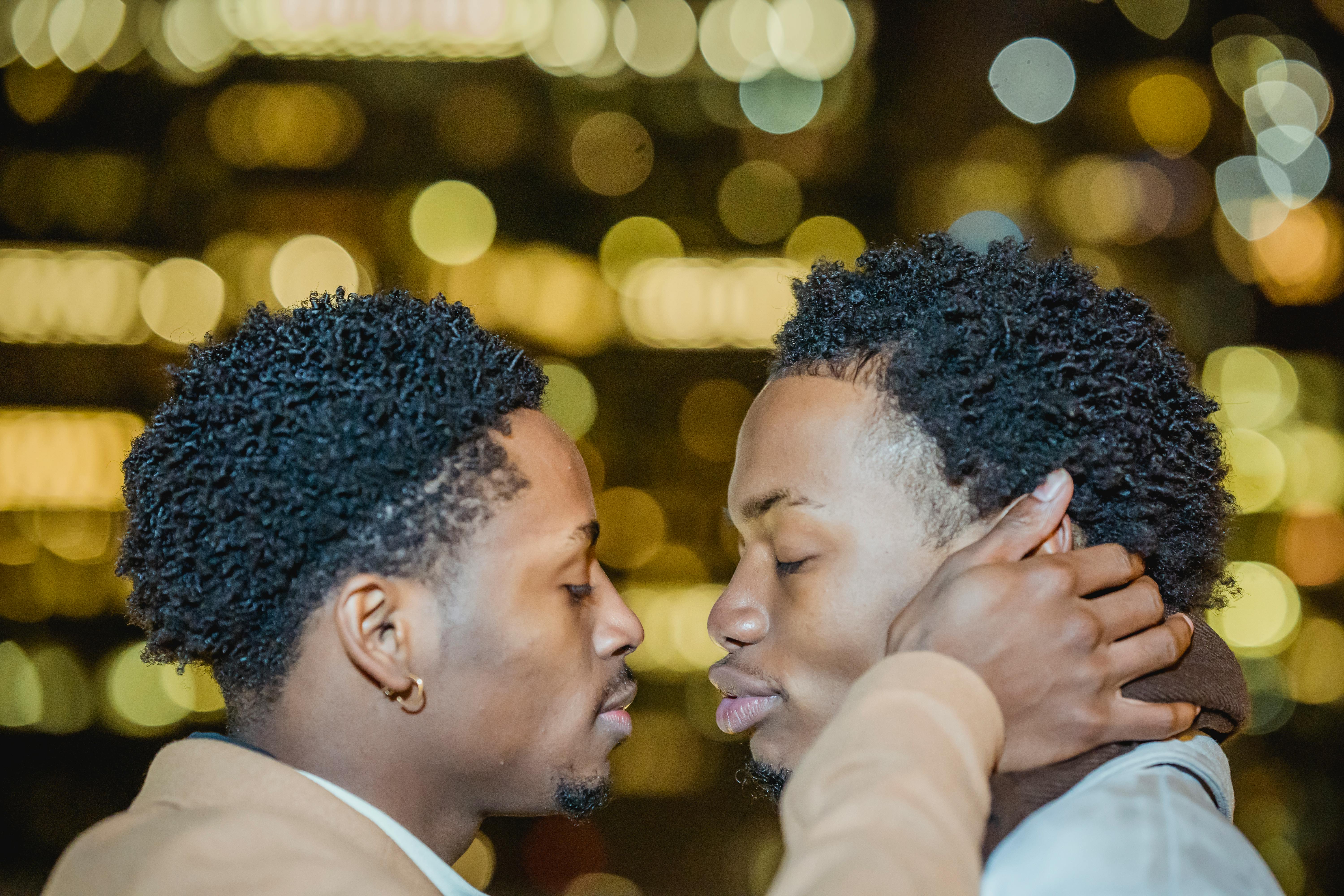 black gay couple hugging in city street at night