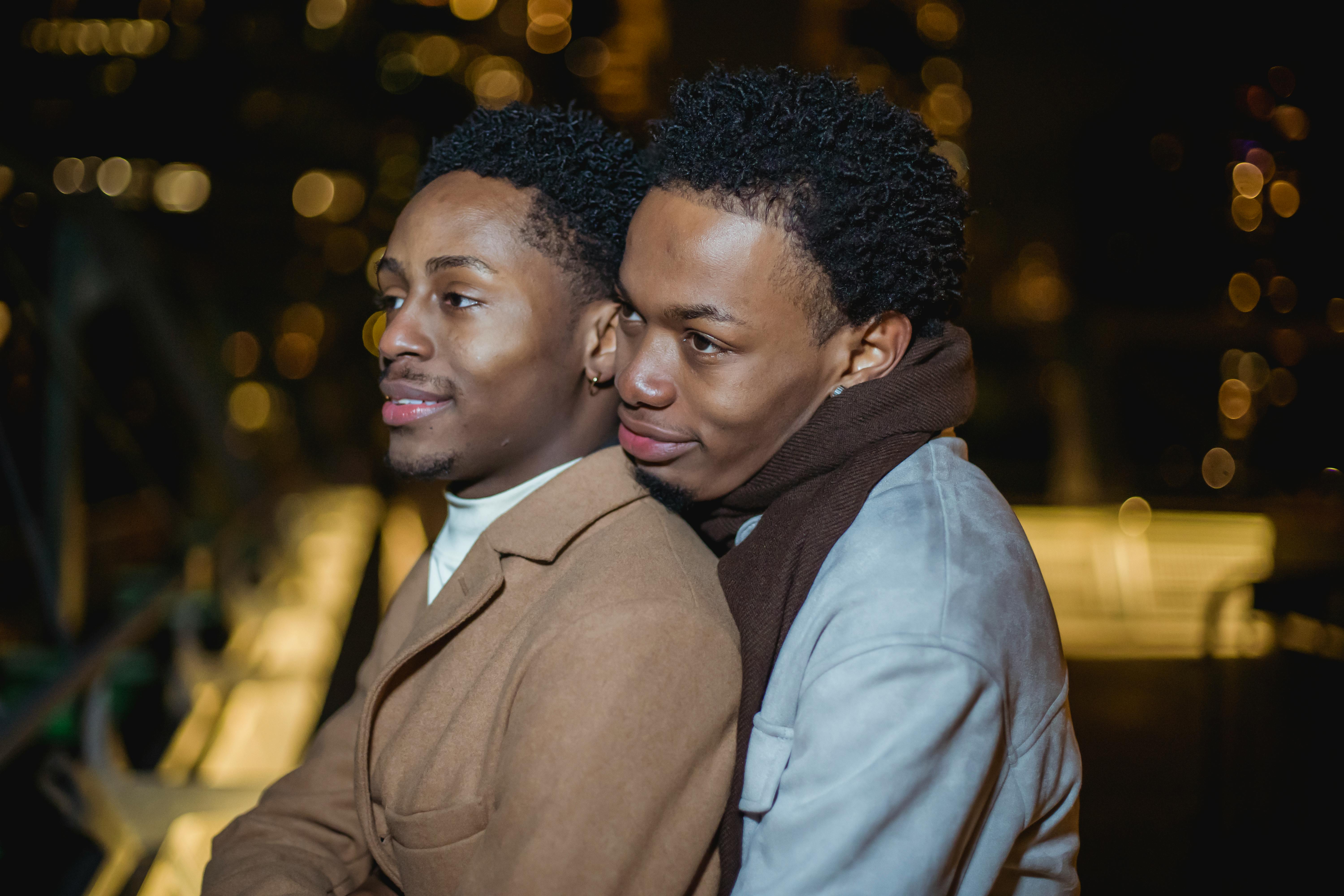 black homosexual male couple cuddling in city street on roof