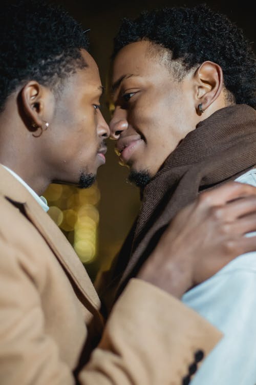 Black gay couple hugging in city street at night