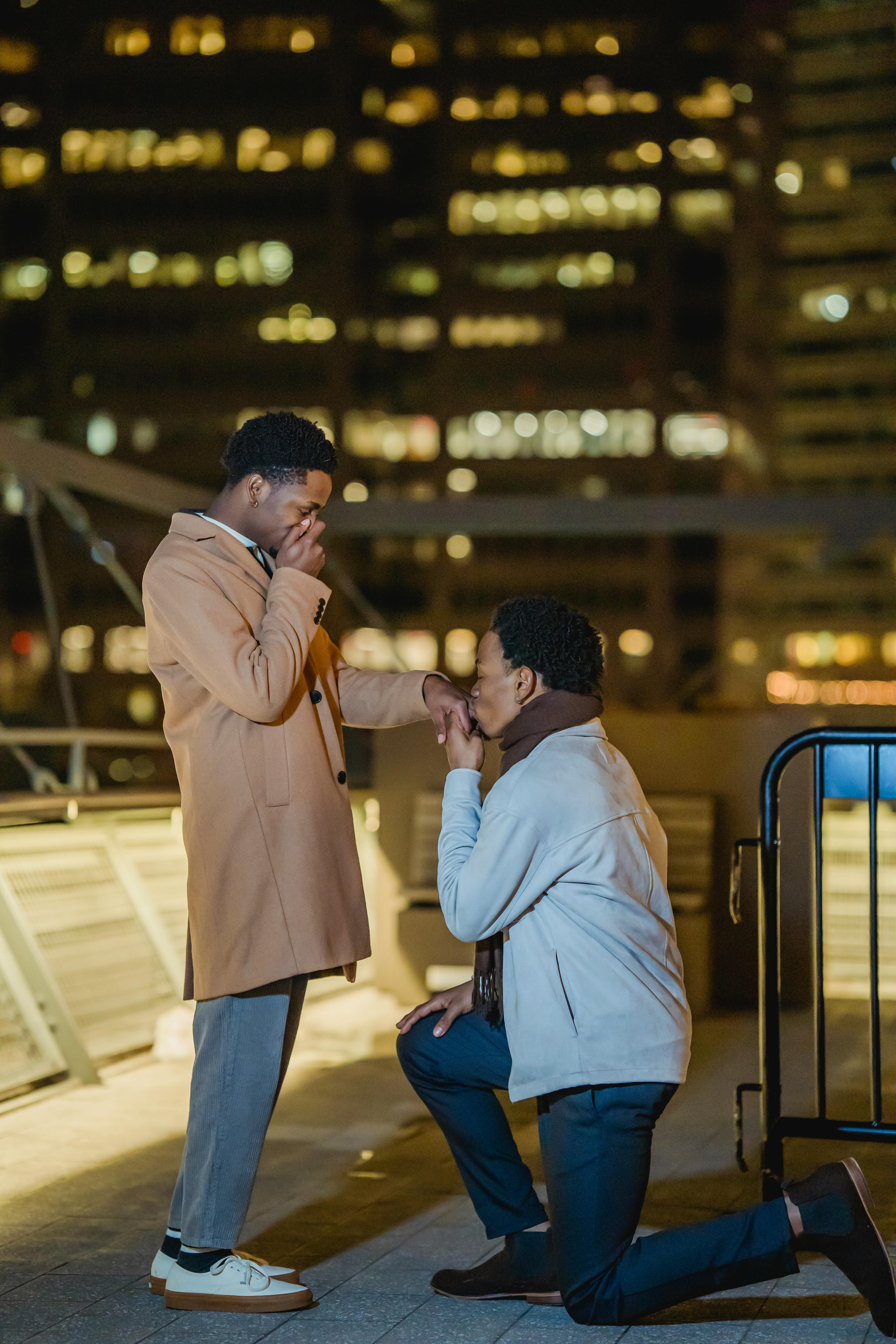 black homosexual male couple making marriage proposal on rooftop