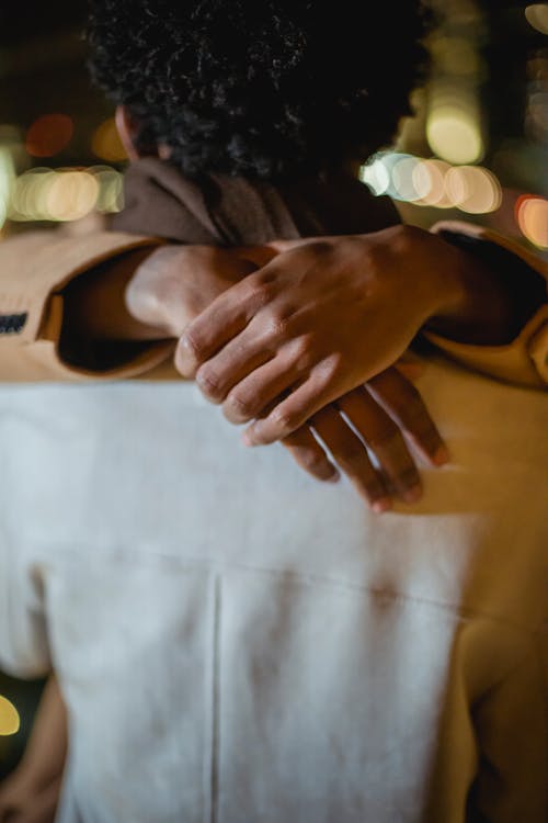 Crop black man hugging anonymous partner