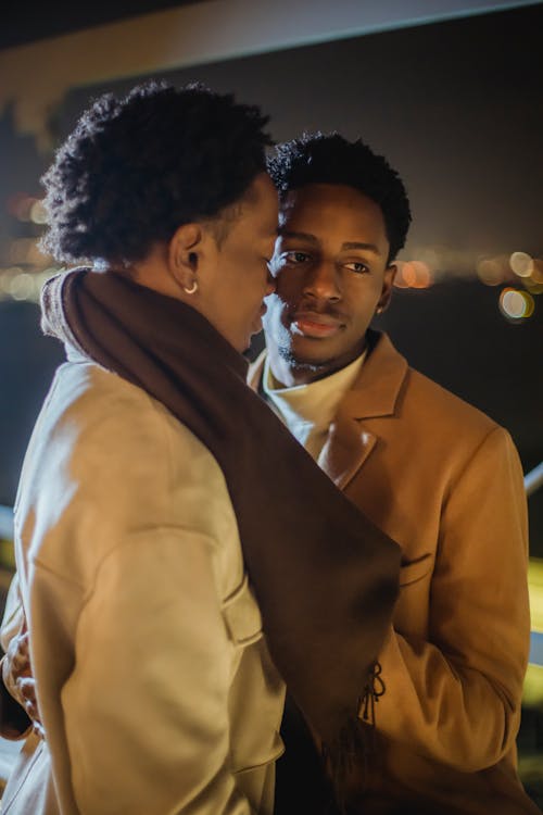 Gentle black homosexual couple on dark street