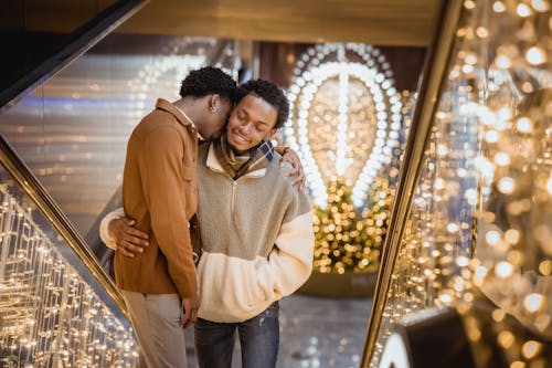 Romantic black gays hugging on stairs with garland