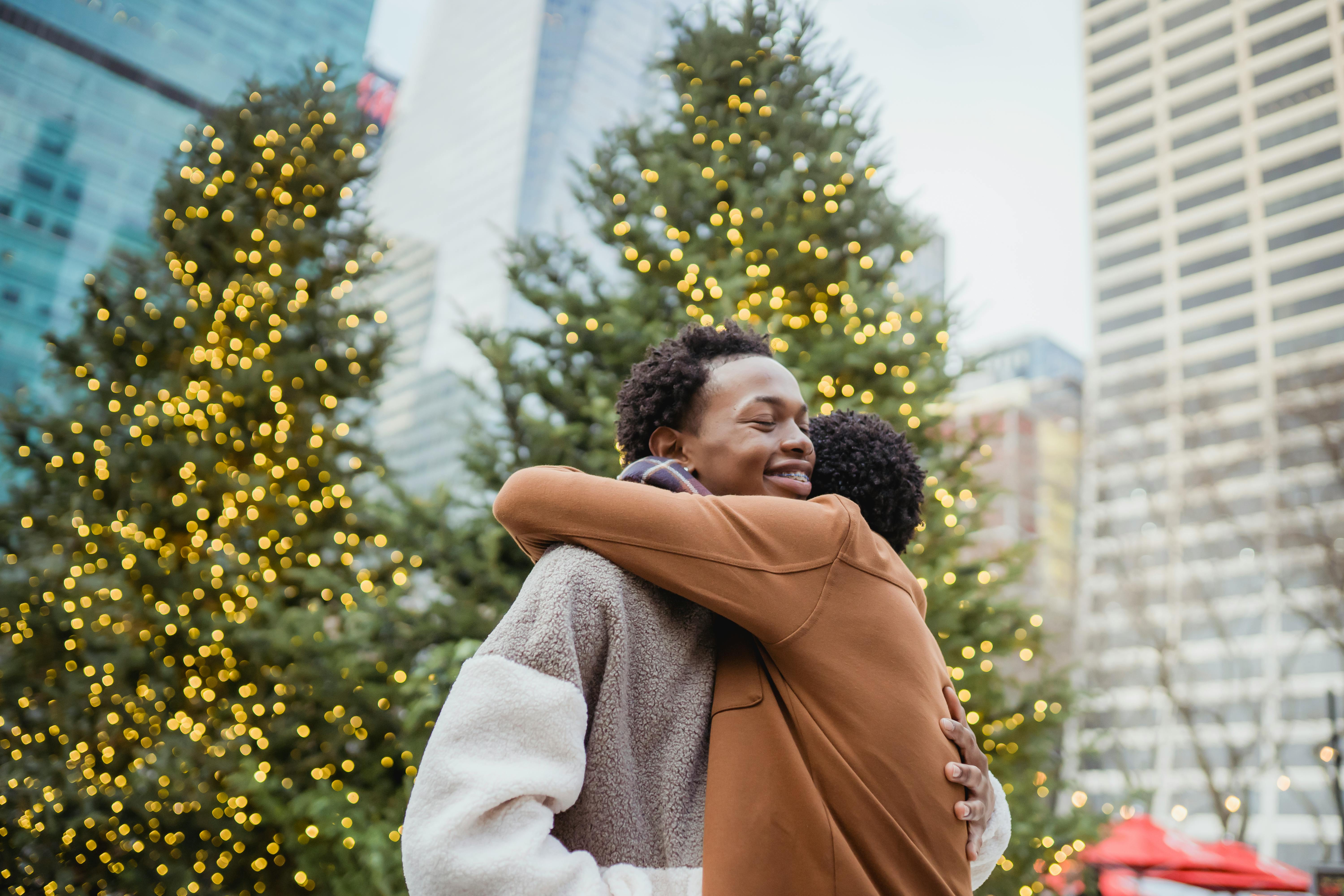 smiling black man embracing unrecognizable homosexual beloved in town