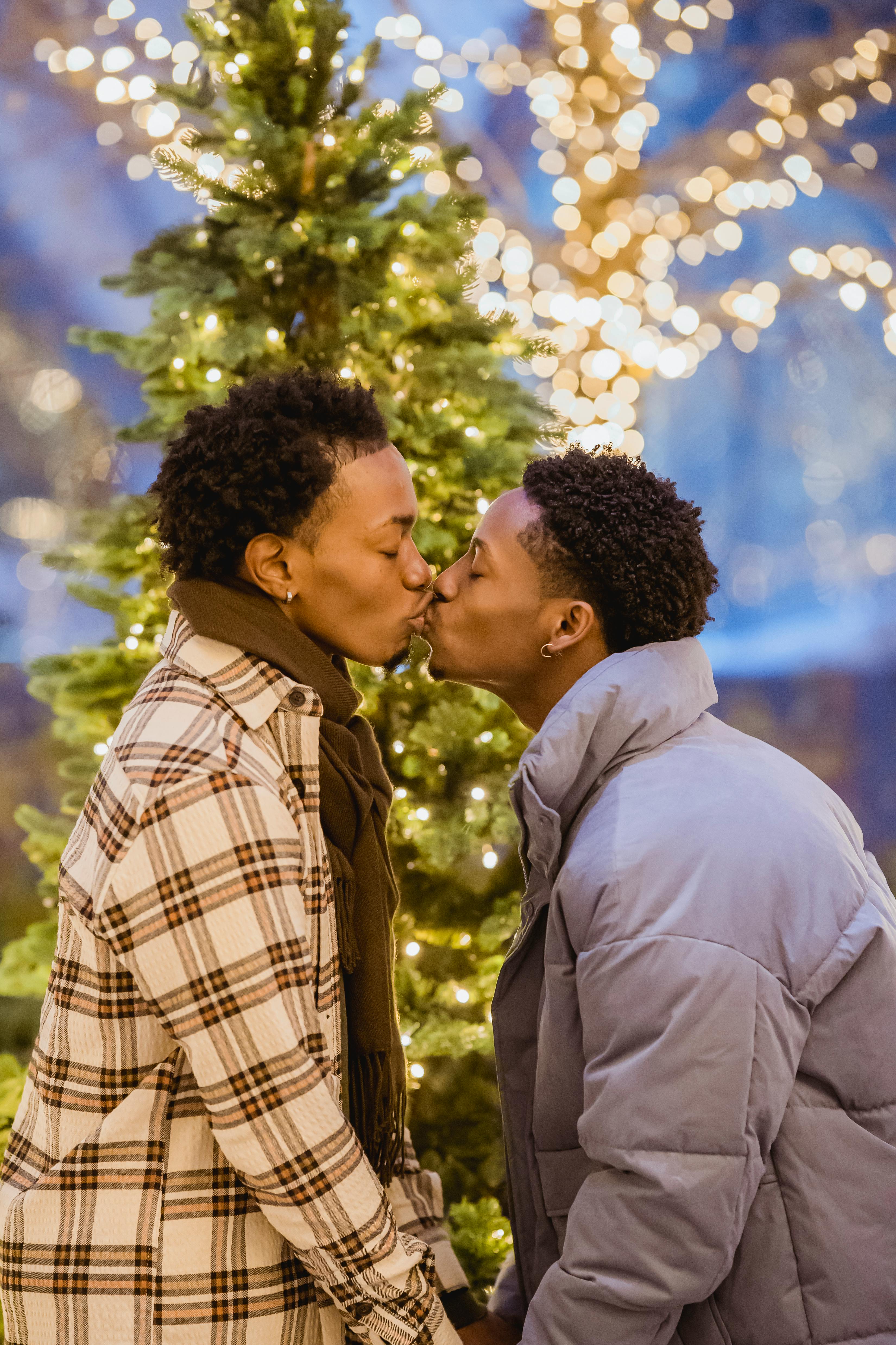 Homosexual black man with unrecognizable boyfriend among Christmas trees · Free Stock Photo