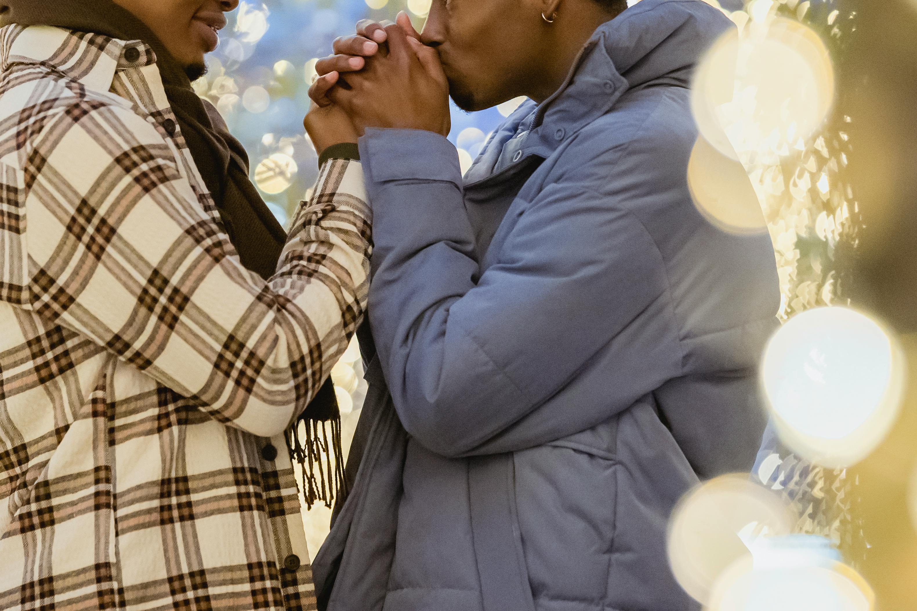 crop black couple of gays holding hands between shiny lights