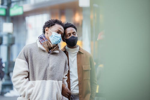 Free Homosexual ethnic couple in face masks on street Stock Photo
