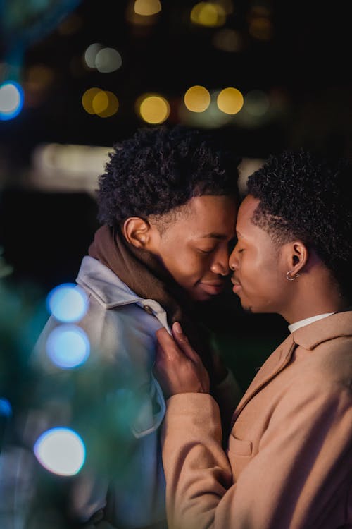 Free Happy young black homosexual men cuddling on street at night Stock Photo