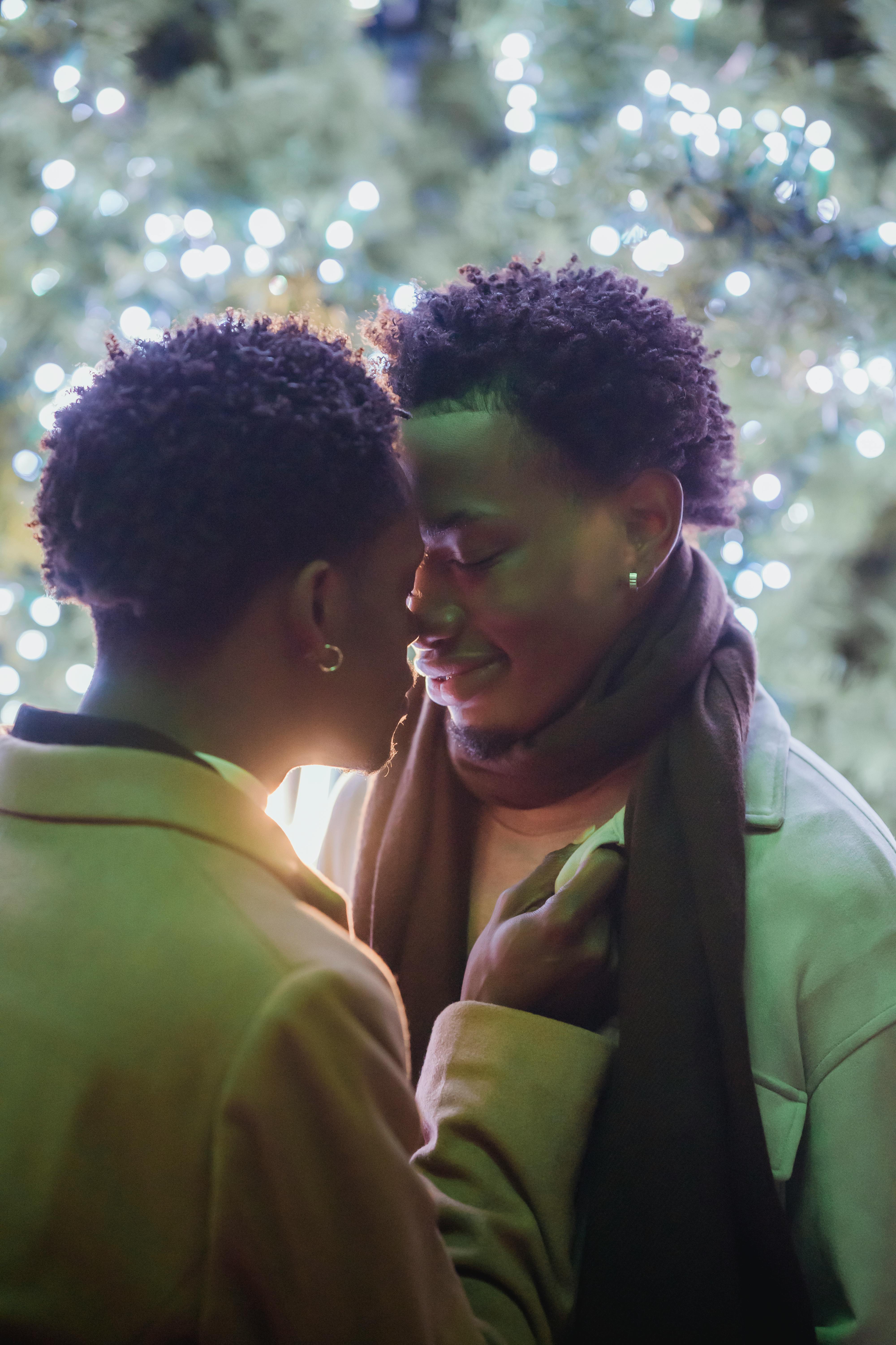 happy young black gay couple hugging with closed eyes on street at night