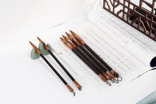 Free A close-up of traditional calligraphy tools and paper featuring ink brushes and Asian script. Stock Photo