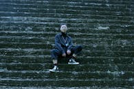A Young Man in a Trendy Outfit Sitting on a Stairway