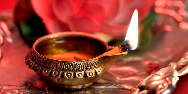 Lit brass diya on silver tray for Griha Pravesh ceremony