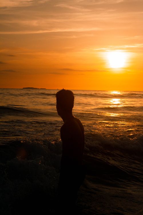 Silhouette of Man in Sea in the Evening · Free Stock Photo