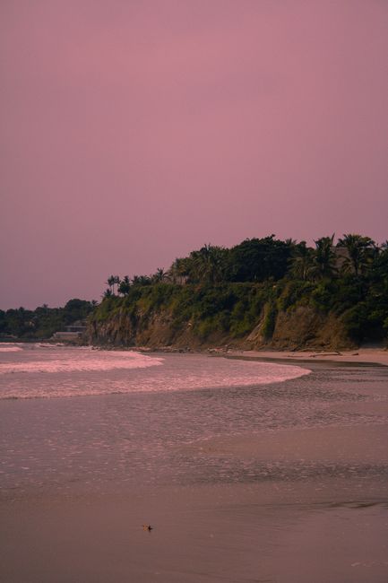 Serene beachscape with cliffs and calm sea under a pink sunset sky, perfect for serene mobile wallpapers.