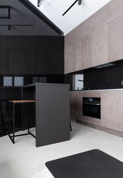 Interior design of contemporary spacious kitchen with dining table and oven in modern apartment