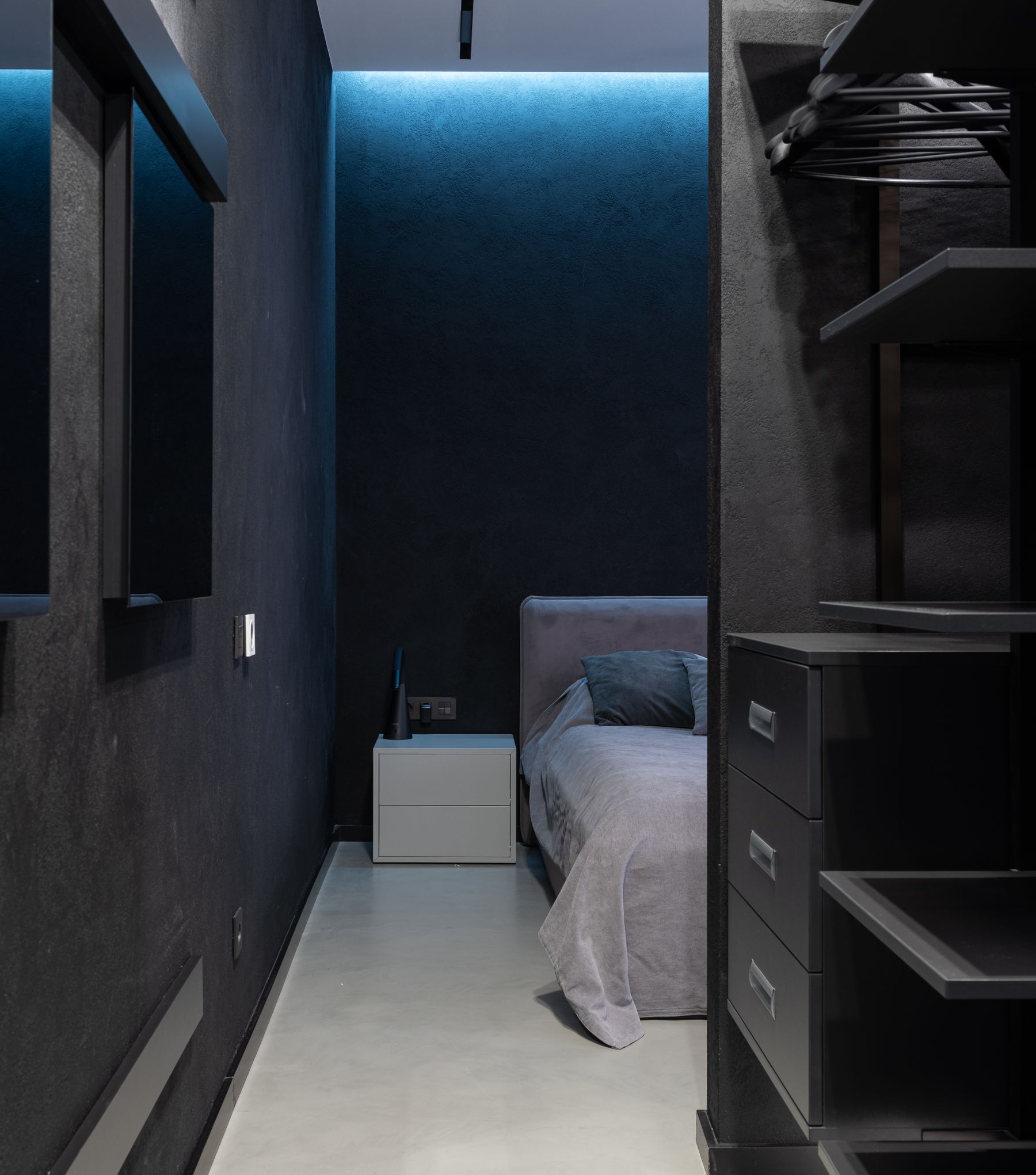 Streamlined bedroom with an open wardrobe, simple bed and a clear floor route