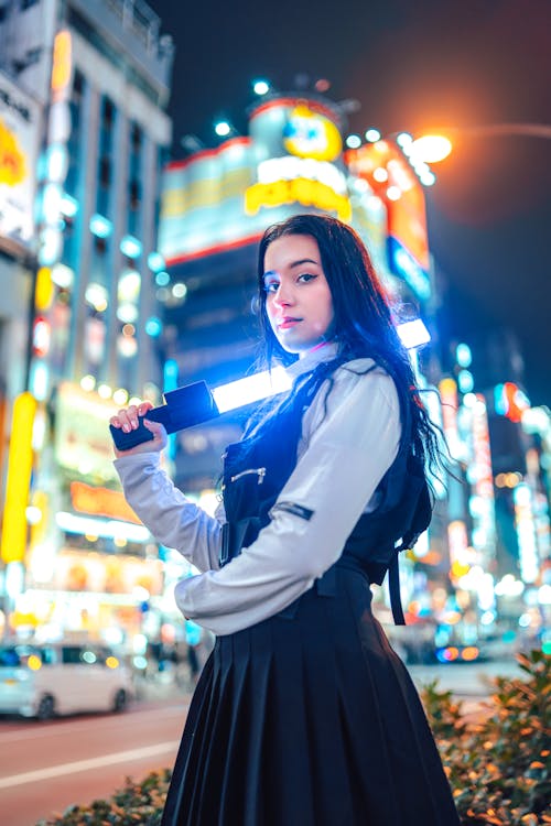 Free A Young Woman in a Trendy Outfit Holding a Light Bar Stock Photo