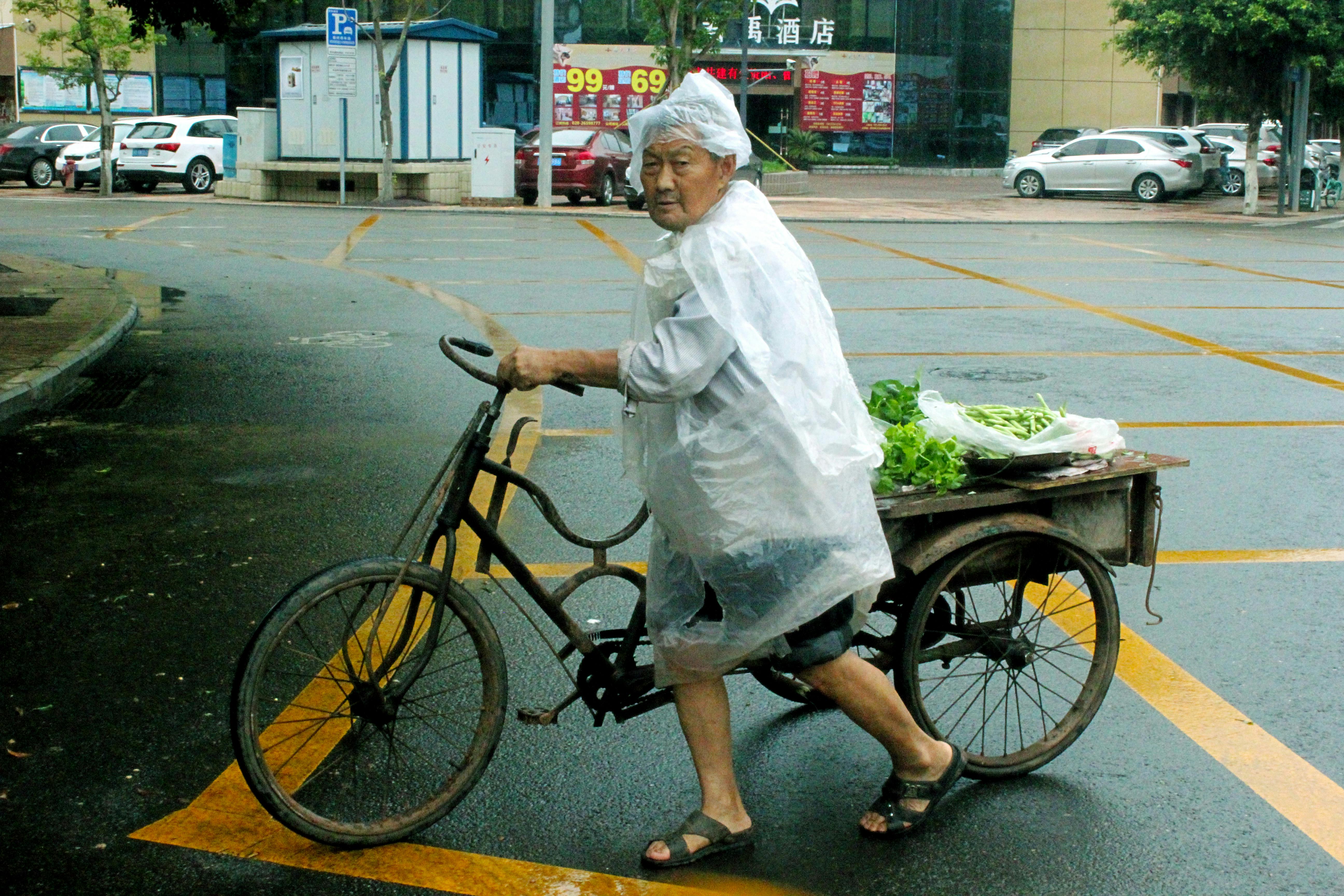 a man walking in the street while holding his bike