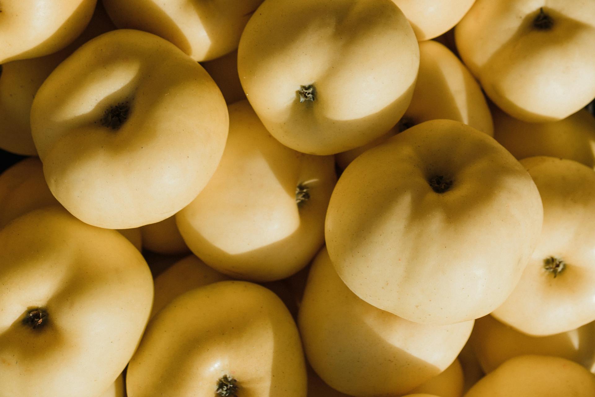 Top view of fresh organic golden apples, highlighting their natural texture and healthy appeal.