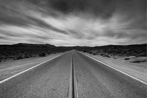 Foto Grayscale Jalan Di Bawah Langit Berawan