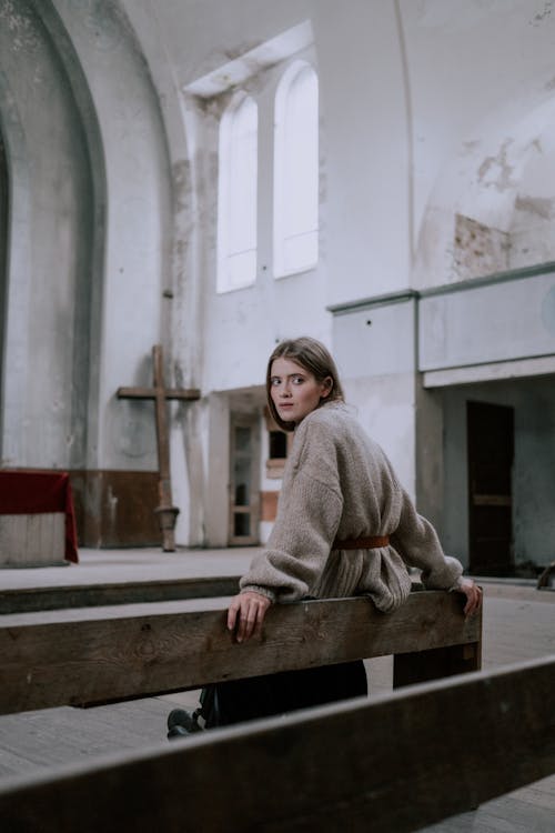 Free A Woman Sitting on a Pew in an Abandoned Church Stock Photo