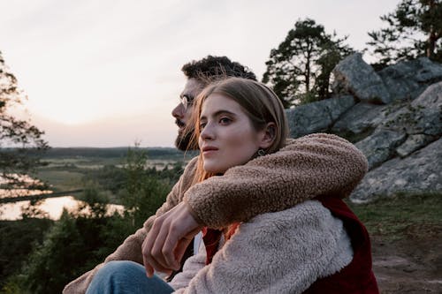 Couple Sitting and Embracing in Countryside