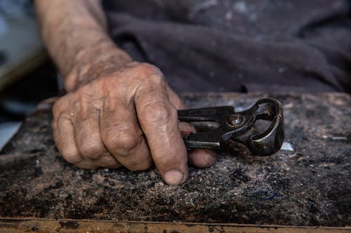 Photo of a Person's Hand Holding Black Pliers