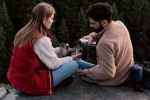 Man and Woman Sitting on Concrete Floor