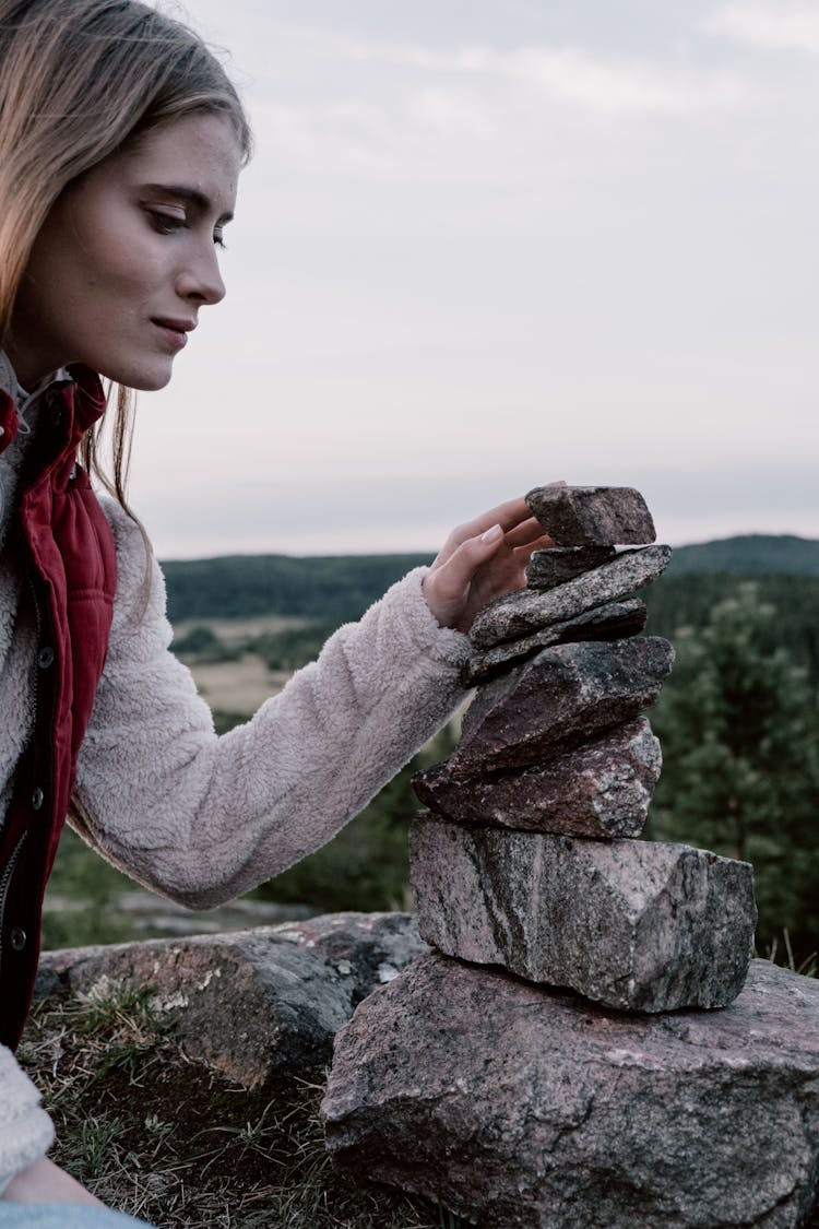 A Woman Balancing A Pile Of Rocks