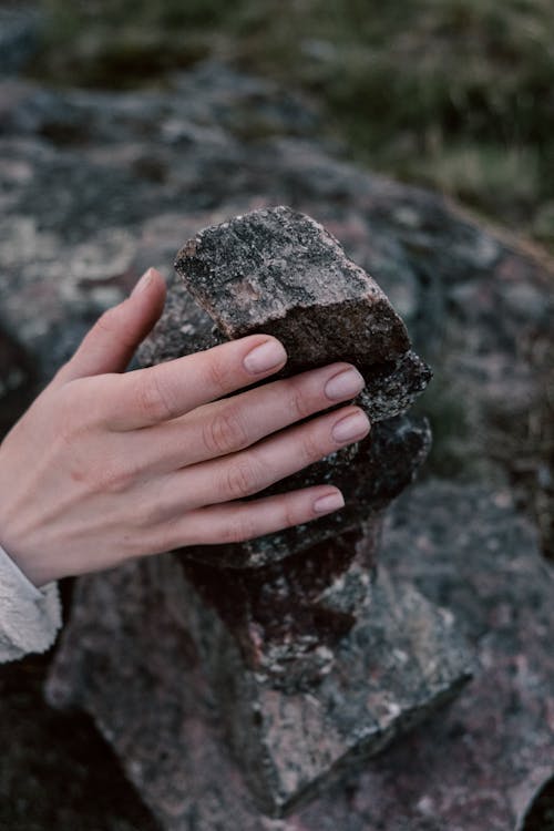 Close-Up Photo of a Person Holding a Pile of Rocks