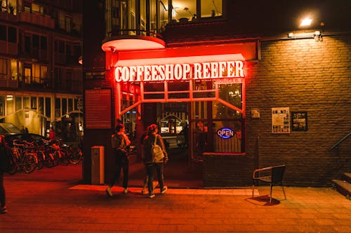 Free People Entering a Coffee Shop at Night Time Stock Photo