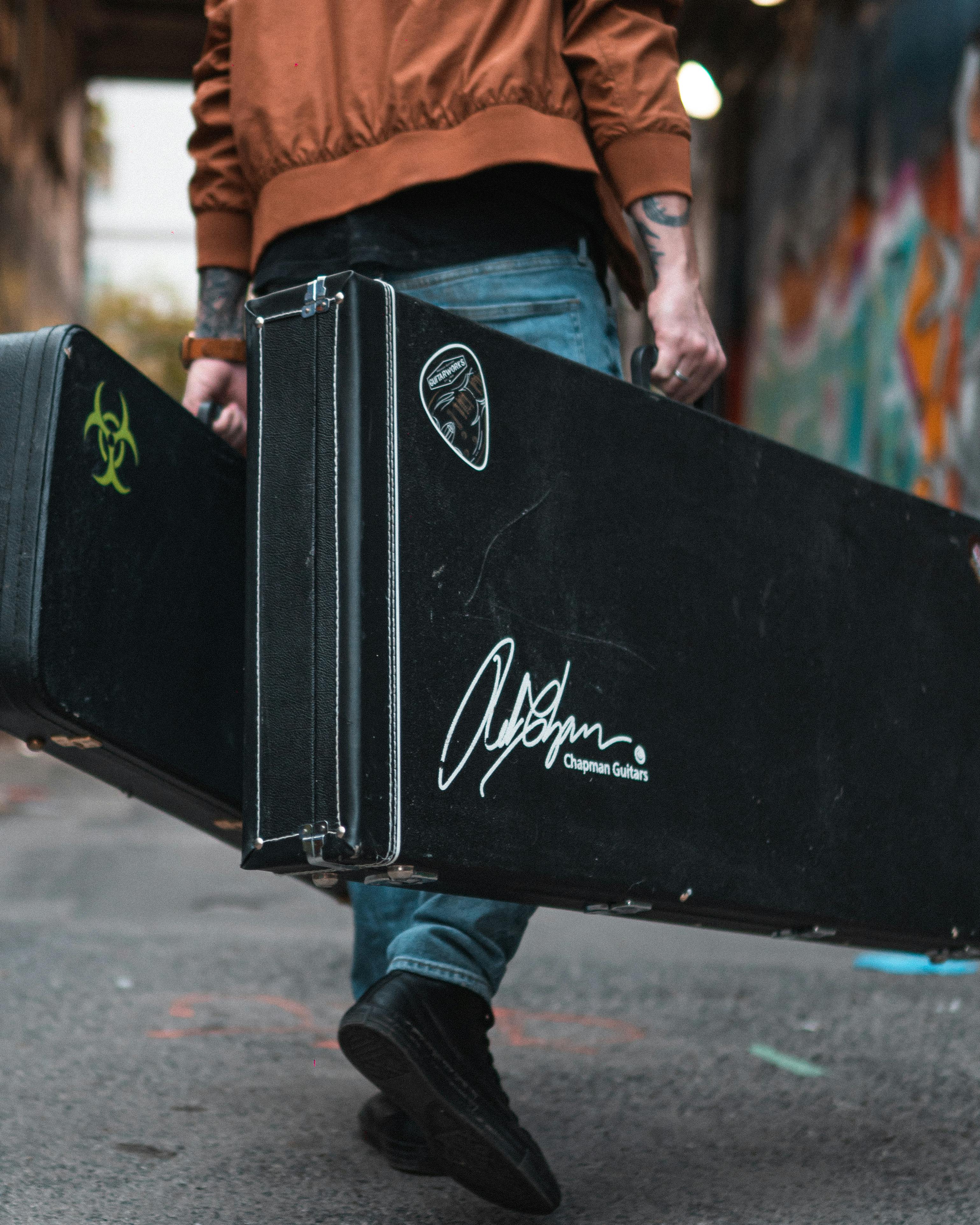 Man Carrying Guitar Cases · Free Stock Photo