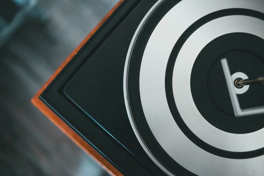 Top view of vintage record player with contrasting circles on platter with metal spindle in house